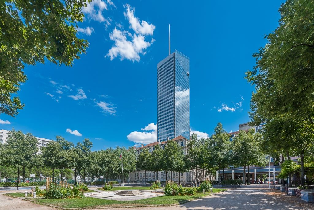 Tour moderne au cœur de Francfort entourée d’un parc urbain et d’arbres
